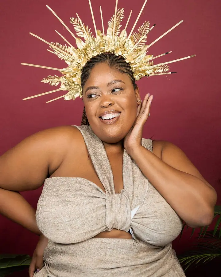 Laughing in a gold crown and a knotted neutral top