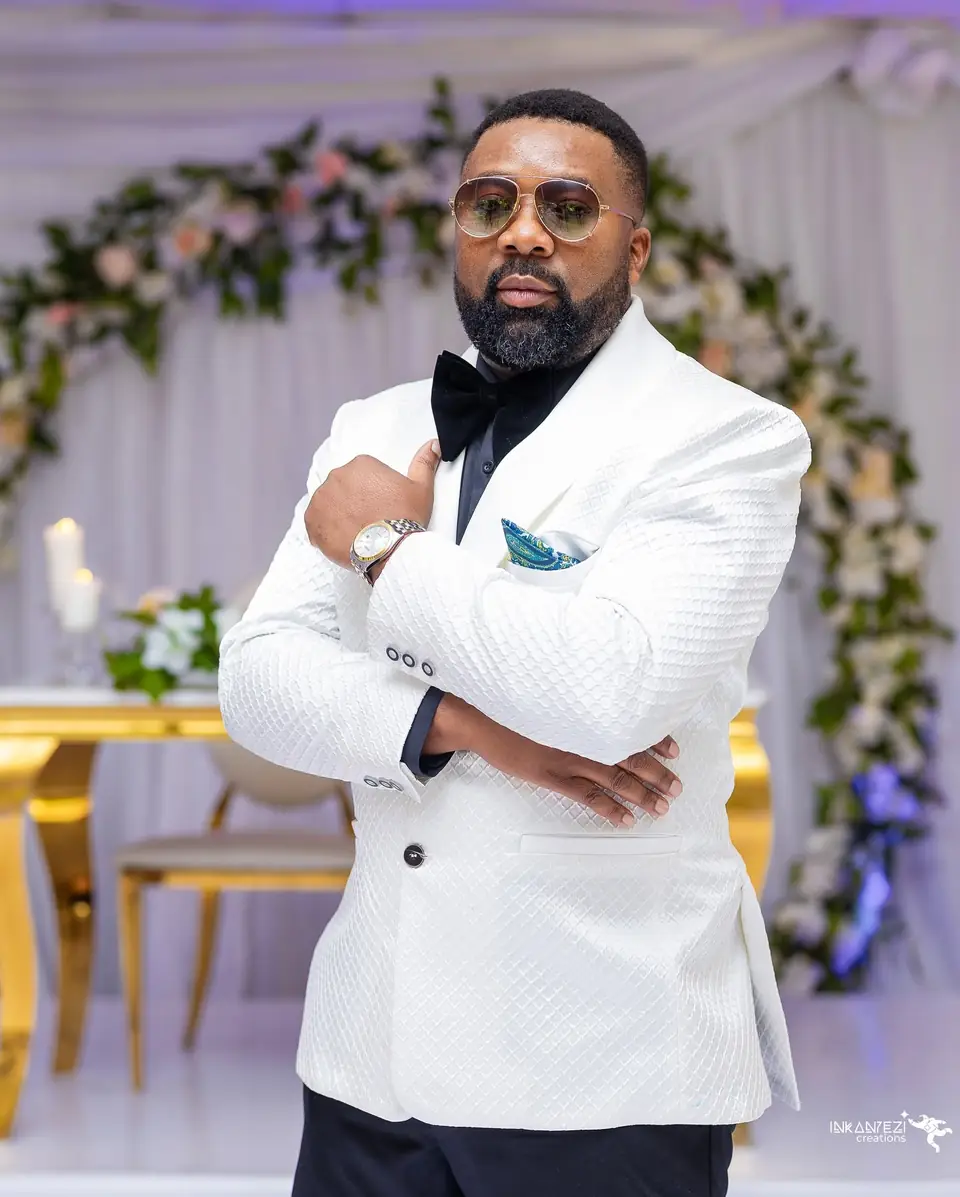 A groom in a white textured dinner jacket and black bow tie